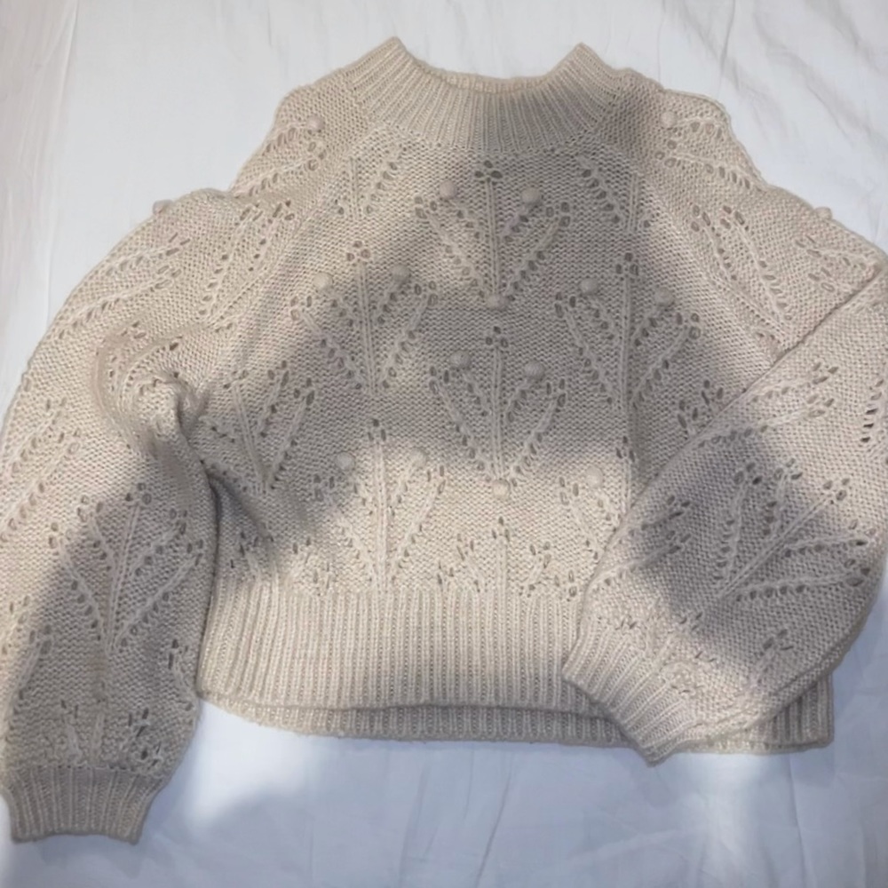 Warm cozy cream colored sweater with cute pom pom design.